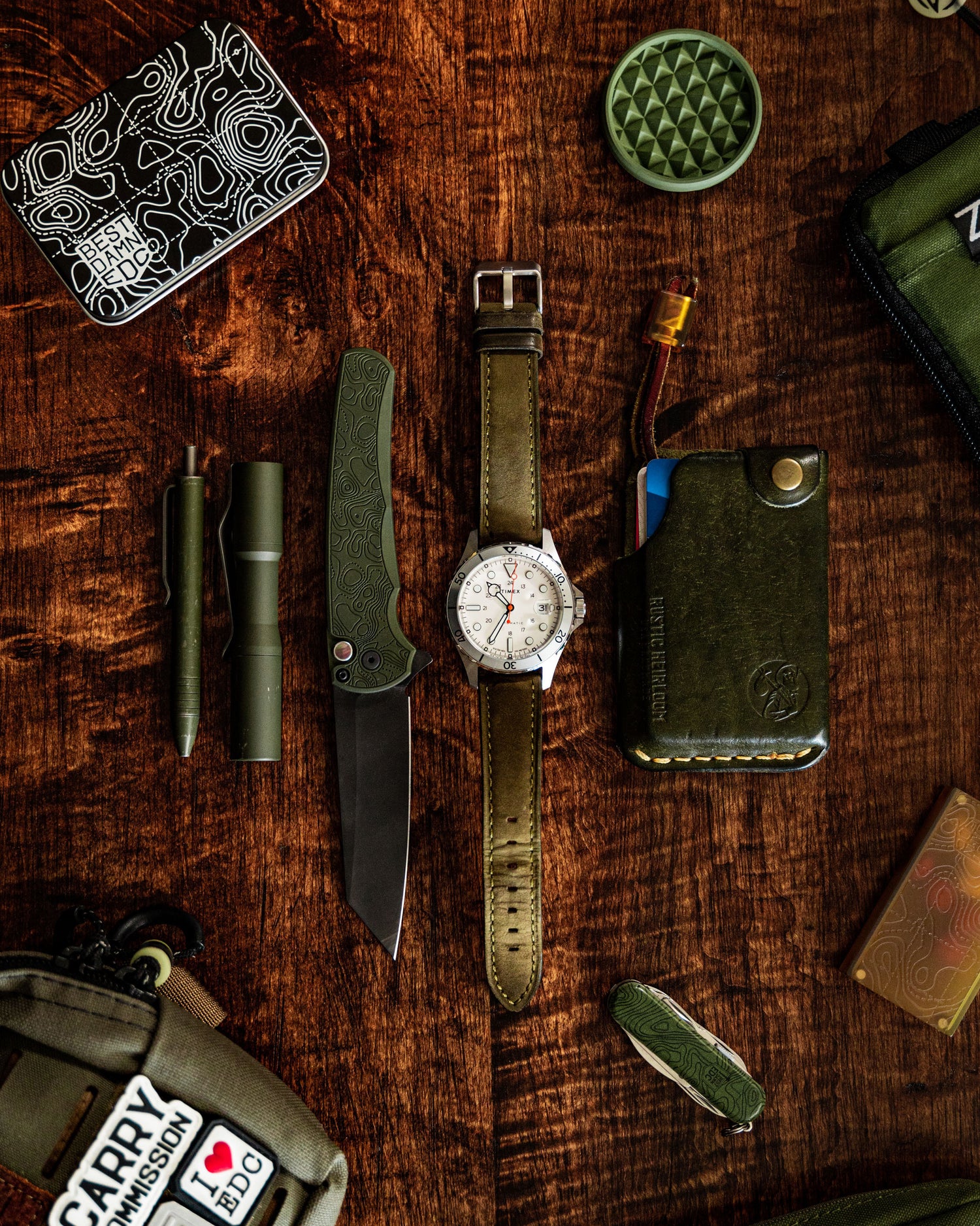 Pro-Tech Malibu Damascus Green Topo Top View Flat Lay with assorted other every day carry items like a watch, wallet, flashlight, pen, etc.