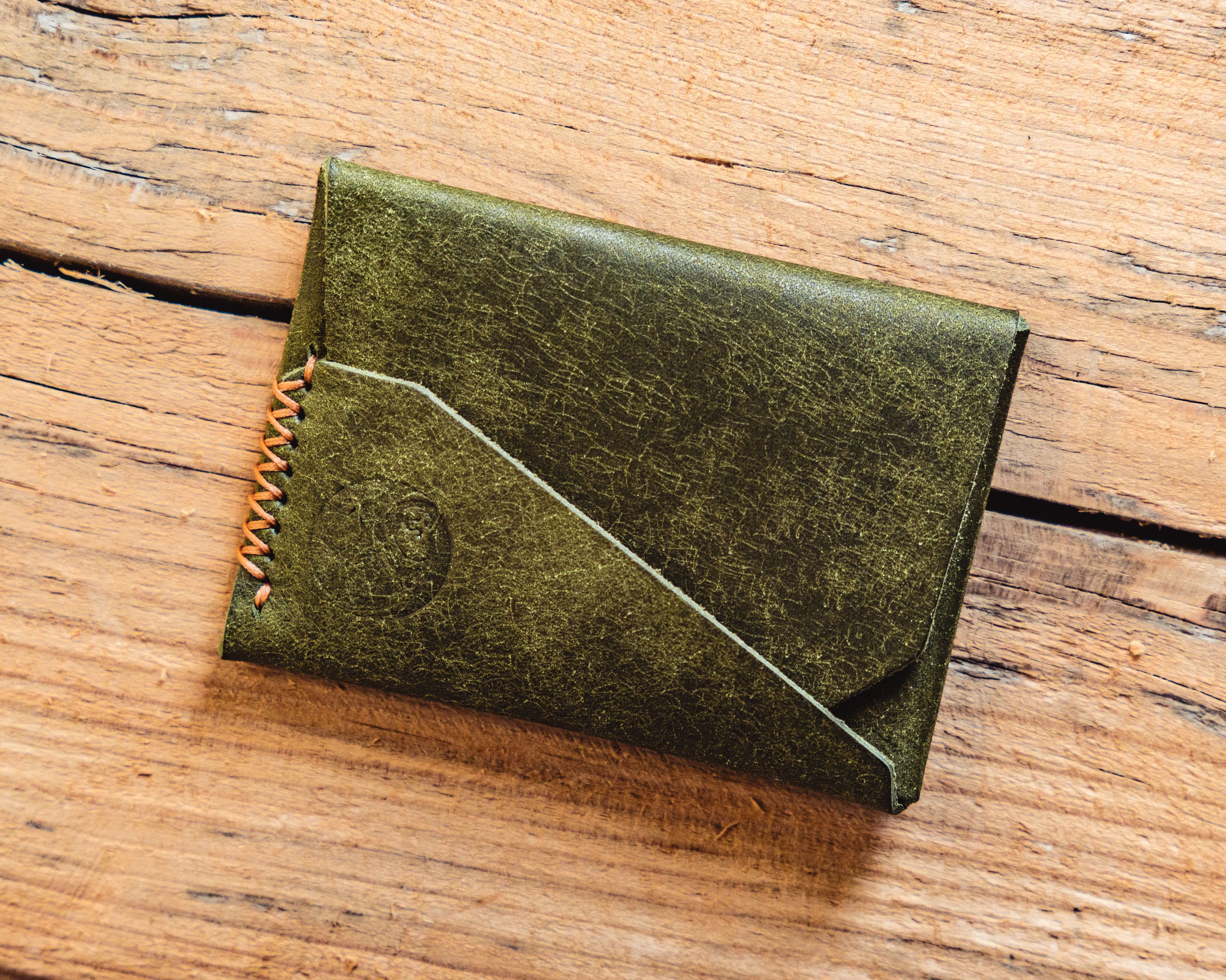 Carry Commission / Open Sea Leather Gun Deck Mini in olive front overhead view on wooden background