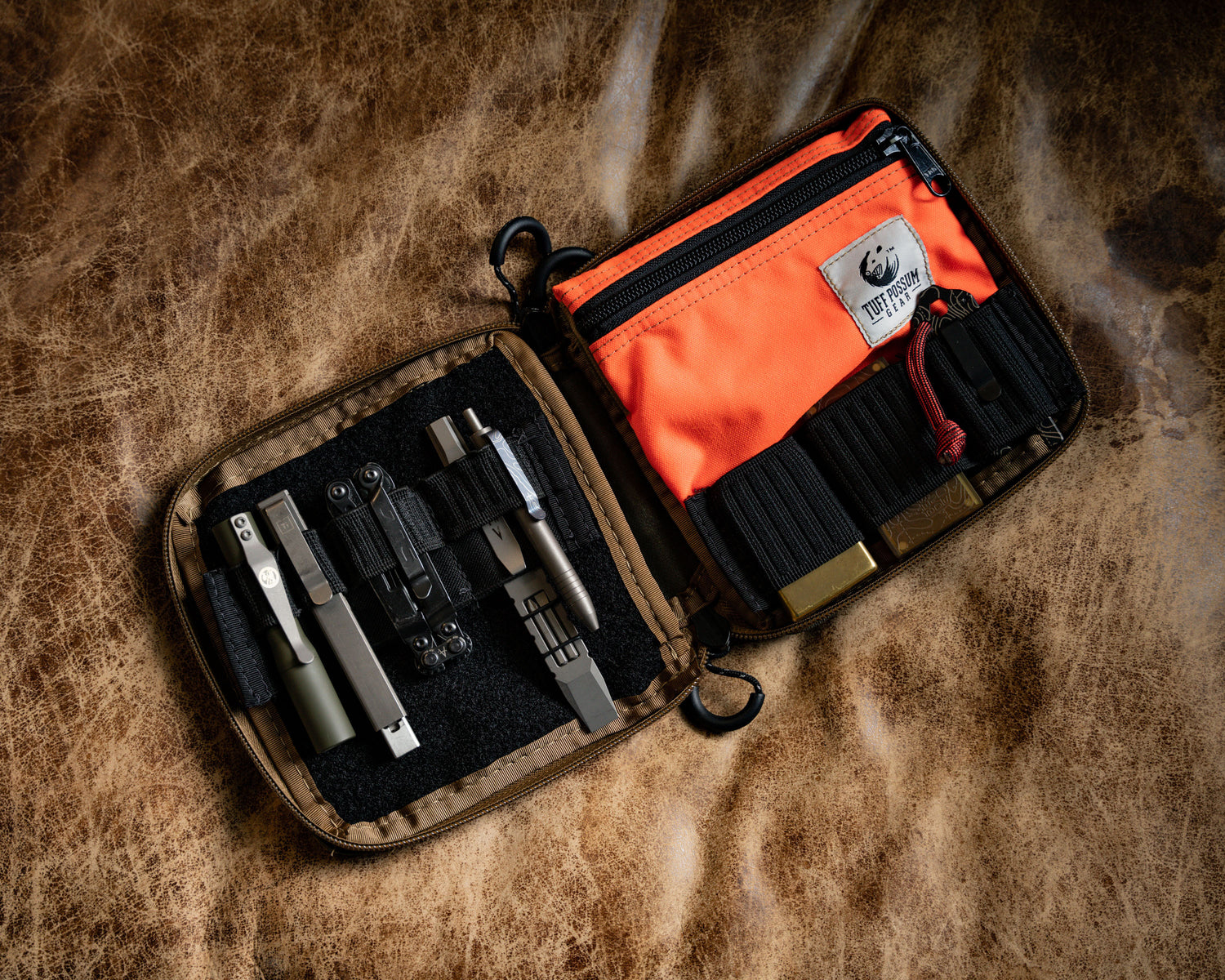 Carry Commission / Blue Ridge Overland Gear EDC Pouch Bundle full open view with lots of gear held in the elastic keepers showcasing the storage capacity on a leather background