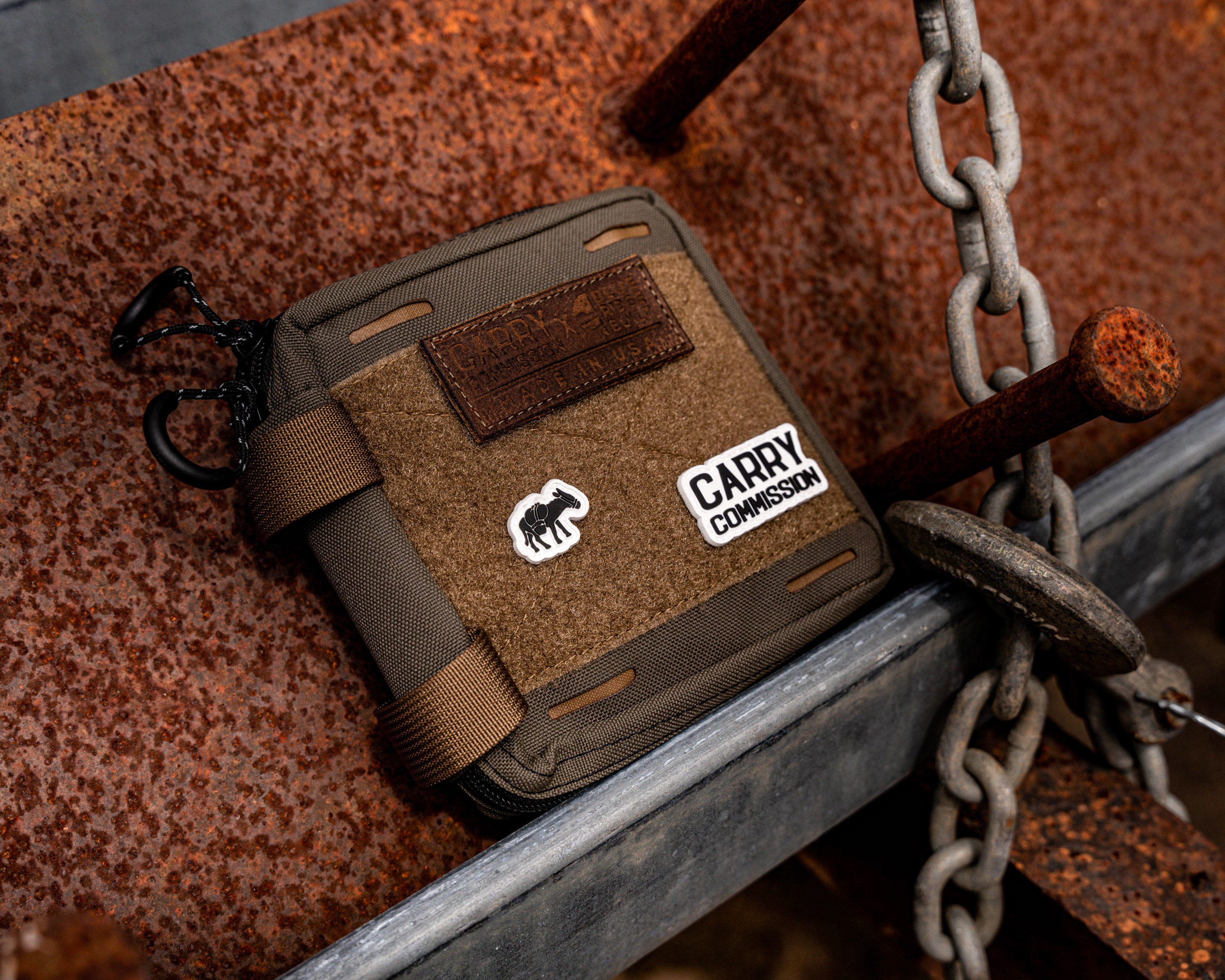Carry Commission / Blue Ridge Overland Gear EDC Pouch Bundle front view set on a rusting metal backdrop with nail and chain also in view