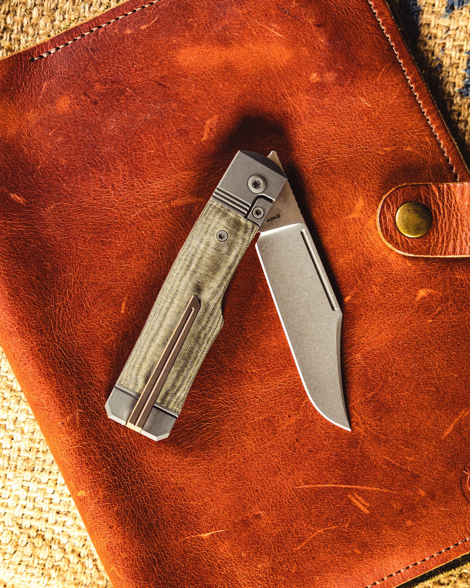 Gunslinger Jack Knife flat lay on top of leather knife folio