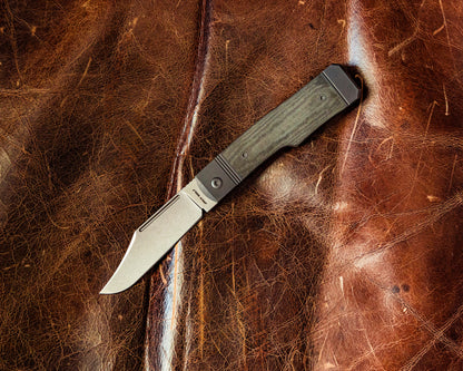 Gunslinger Jack Knife flat lay on leather surface