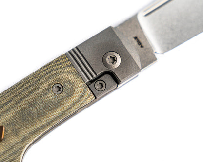 Gunslinger Jack Knife close up view of the micarta and titanium on white background