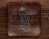 Blue Topo Tough Clip Front View placed on a leather carry commission coaster sitting on a wood background