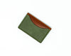 Overhead view of the back of a brown and green bifold wallet on a white background