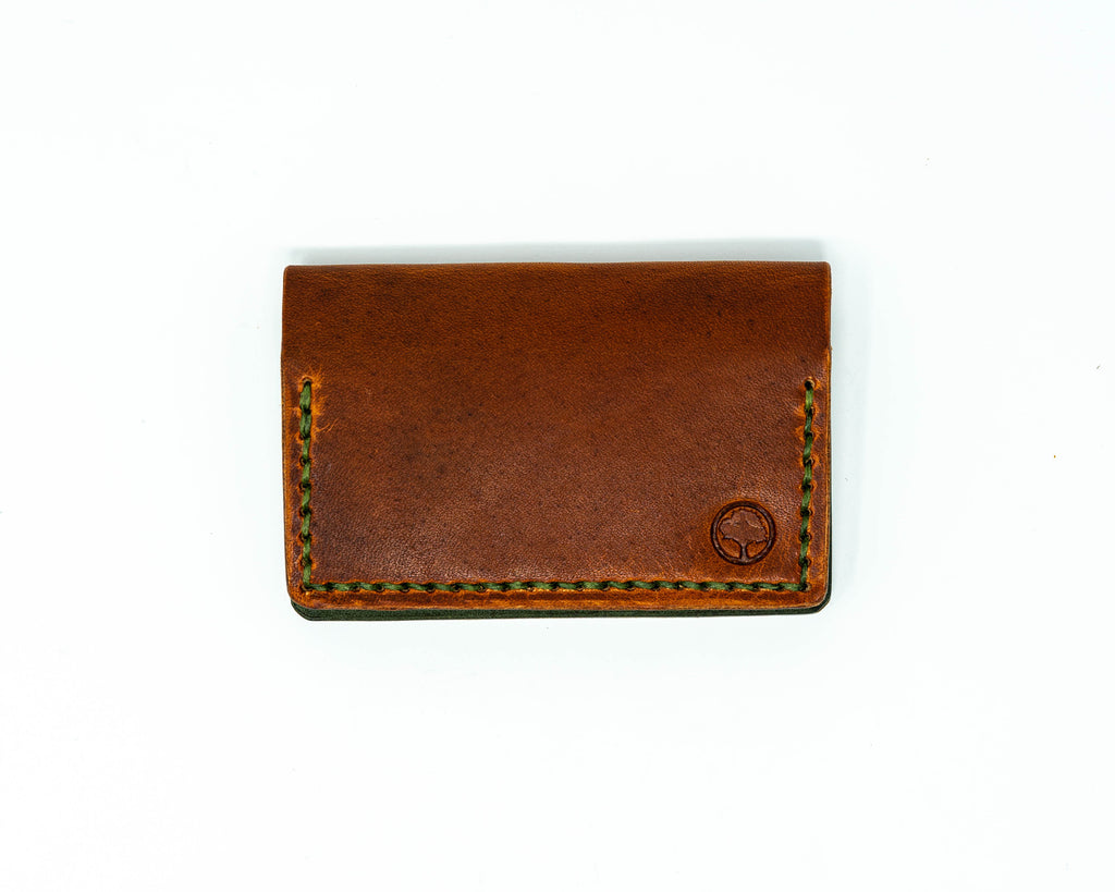 Top view of bifold brown and green wallet on a white background