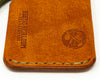 Zoomed in perspective of front bottom of Rustic Heirloom's Carry Commission  Hitchhiker Wallet in leather with olive drab thread and paracord.