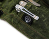 PNW Bushcraft Maple Waxed Canvas Close of single pocket of PNW Bushcraft Knife Roll in Green with a multi-tool on a white background.
