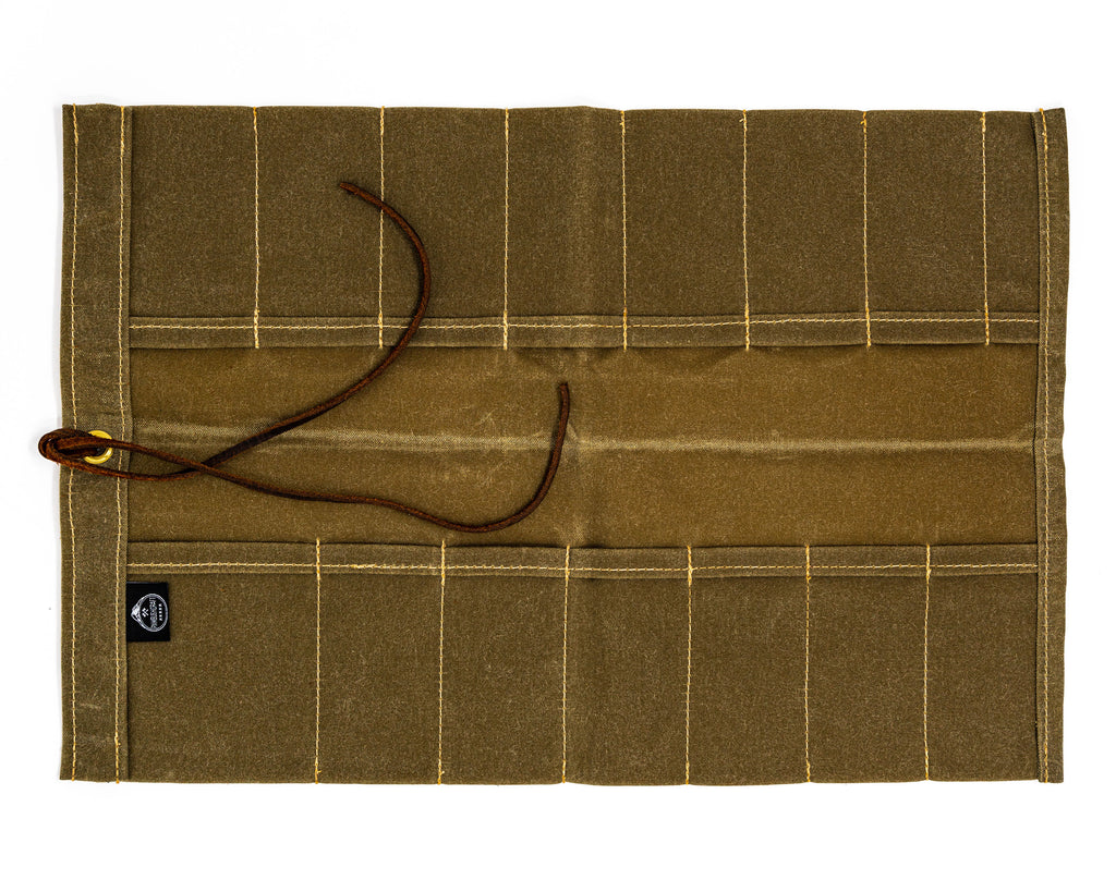 Overhead view of open PNW Bushcraft Maple Waxed Canvas Knife Roll in Tan on a white background.