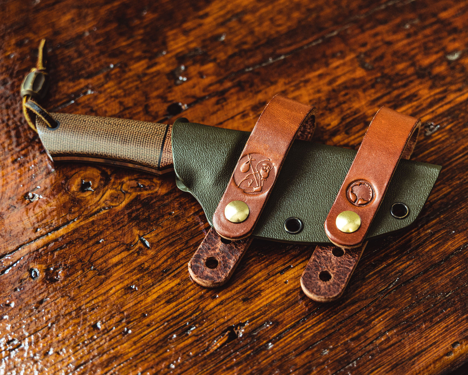 Carry Commission / Redeemed Creations Scout Straps attached to knife sheath overhead view on wooden background