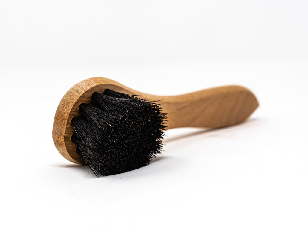Smith's Leather Balm Horse Hair Dauber Brush laid on its side on white background. 