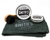 Smith's Leather Balm Horse Hair Dauber Brush laid on its side on Smith's Leather Balm Shop Rag and two Smith's Leather Balm Tins on a white background. 