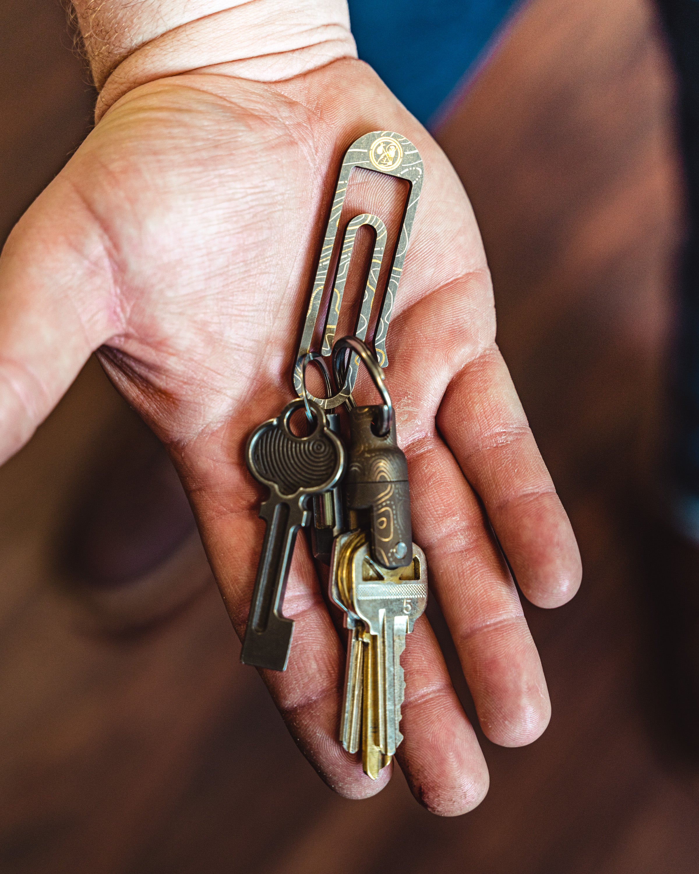 Carry Commission / Urban Carvers Keyper MQR Bronze Topo side view with keys on a tough clip in the palm of a hand.