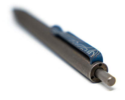 Top down view of the Titanium Carry Commission &amp; Big Idea Design mini click pen on a white surface