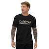 Front side of black Carry Commission T-shirt sporting the lettering and man holding bindle on shoulder being modeled by tattooed male.